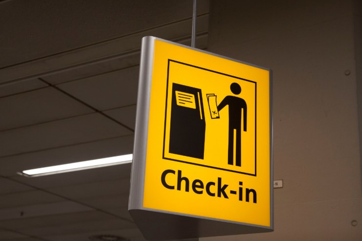immagine di un cartello che segnala dove si trova il check-in un aeroporto