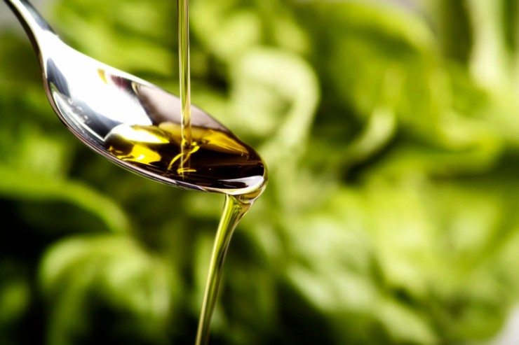 persona che versa dell'olio su un cucchiaio